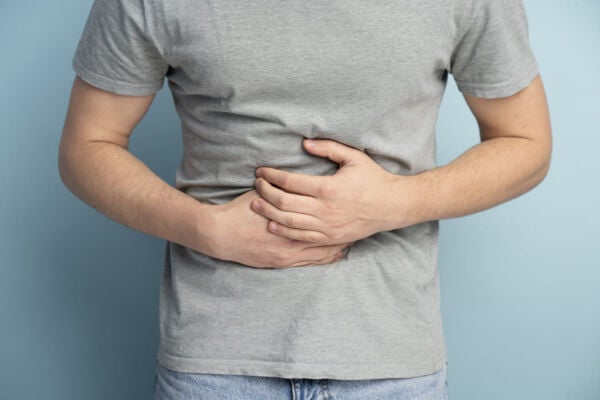 Man with hiatal hernia holding his stomach tightly