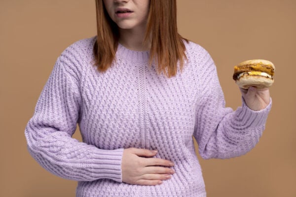 Woman holding her tummy while eating