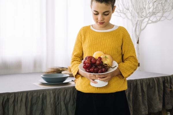 Woman with acid reflux holding a basket of fruits