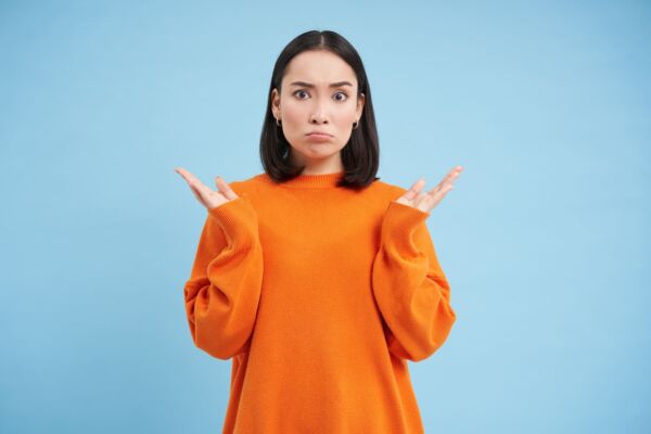 Women with heartburn confused face shrugs shoulders