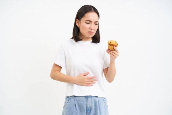 Women with heartburn holding cupcake