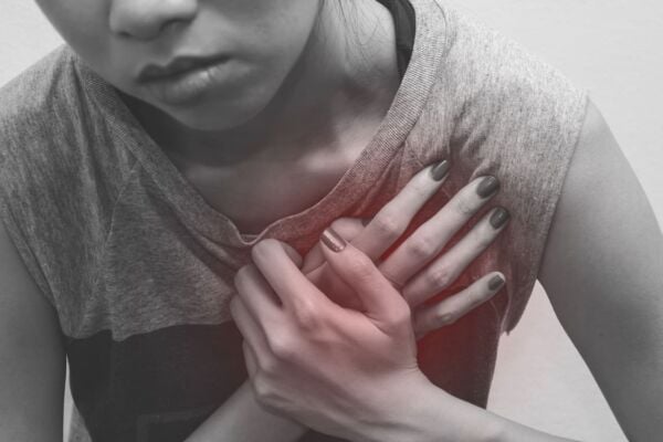 Women with heartburn holding her chest tight