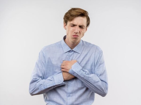 Man with hiatal hernia in pain holding his chest