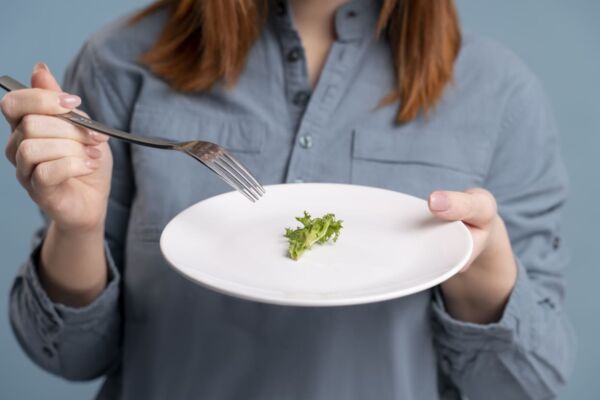 Person with heartburn eating small portion of vegetable