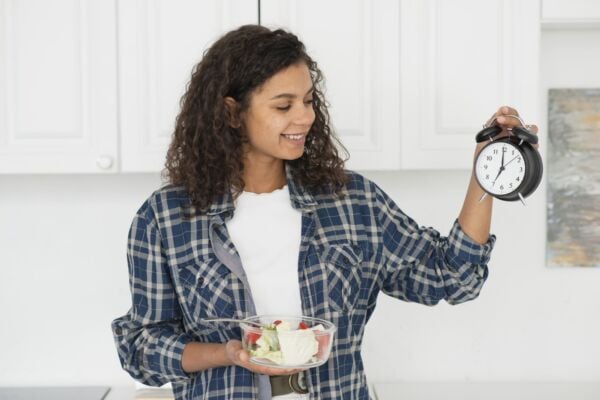 Woman with acid reflux holding a plate of healthy food