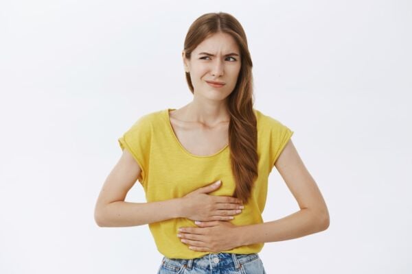 Woman with hiatal hernia holding his stomach tightly