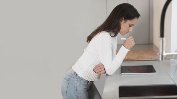 Woman with gastroparesis vomiting in the sink
