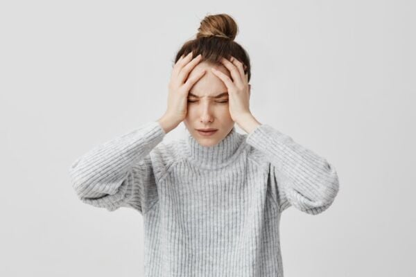 Women with heartburn stressed holding her head