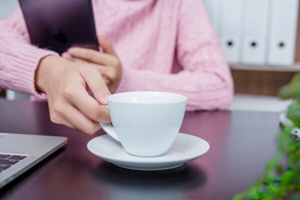 Person reaching for coffee while seeking heartburn relief solutions