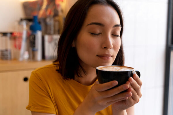 Woman enjoying coffee without heartburn symptoms at home