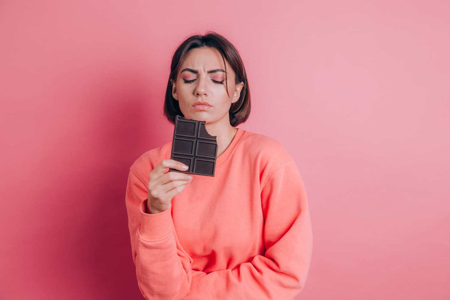 Sad woman holding a chocolate bar