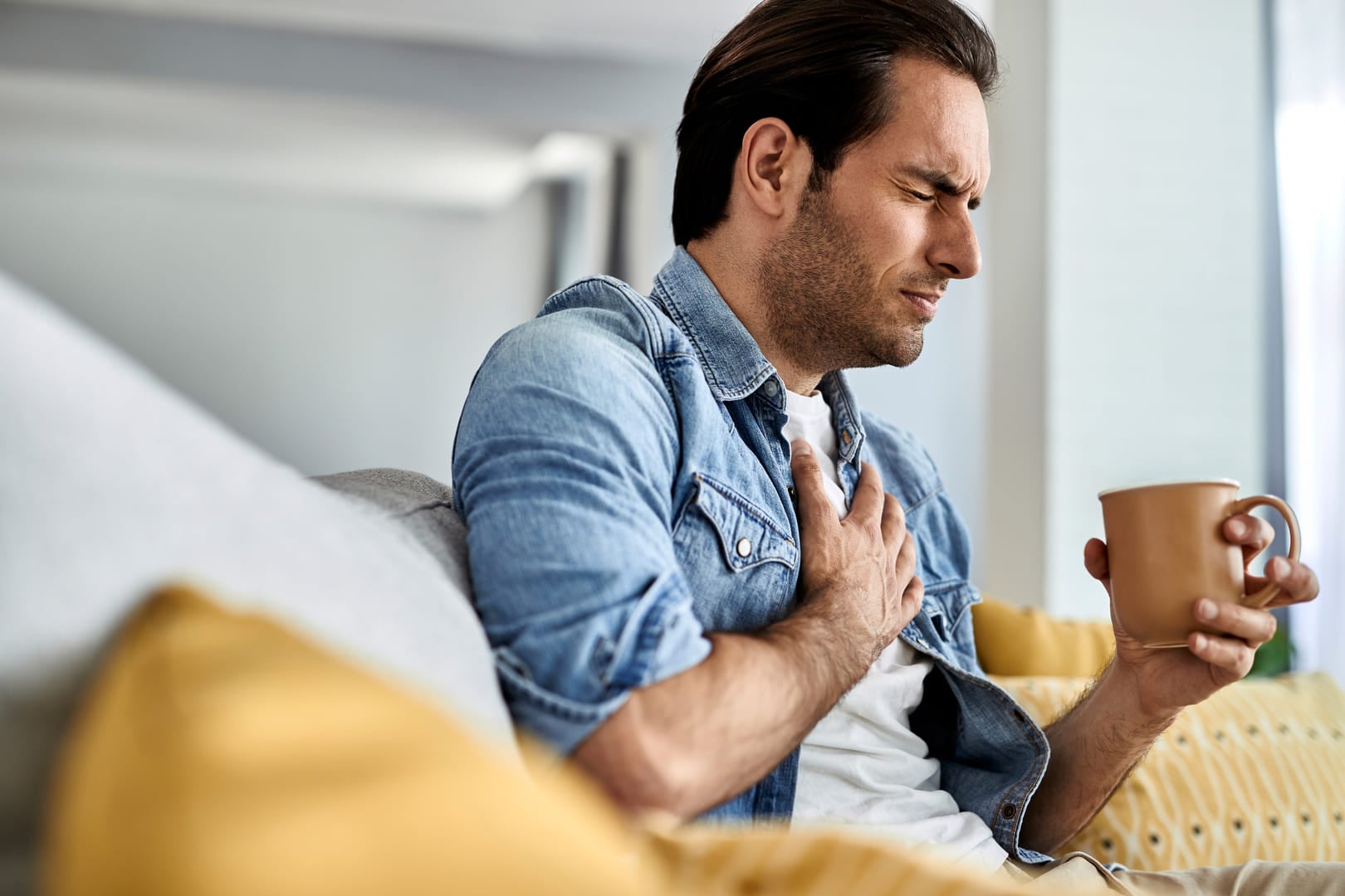 Man having a heartburn while drinking coffee