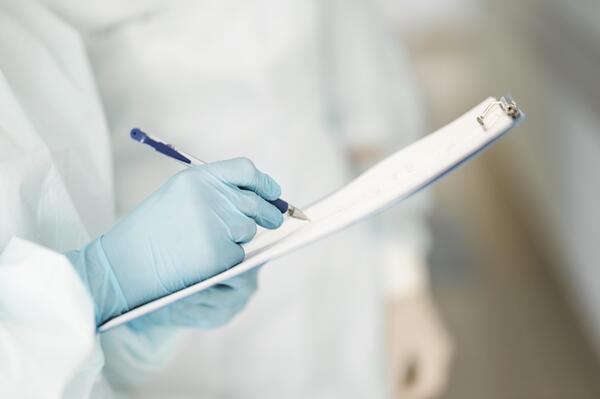 Hands of heartburn doctor writing in clipboard