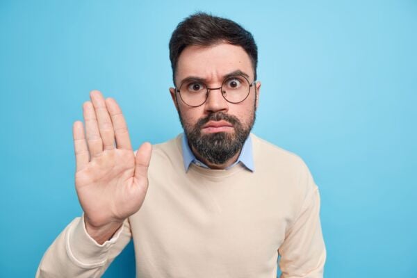 Man with heartburn doing stop gesture