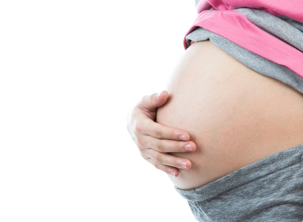 Pregnant woman with hiatal hernia holding her tummy