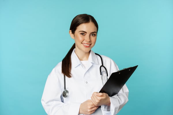 Hiatal hernia doctor smiling while holding clipboard