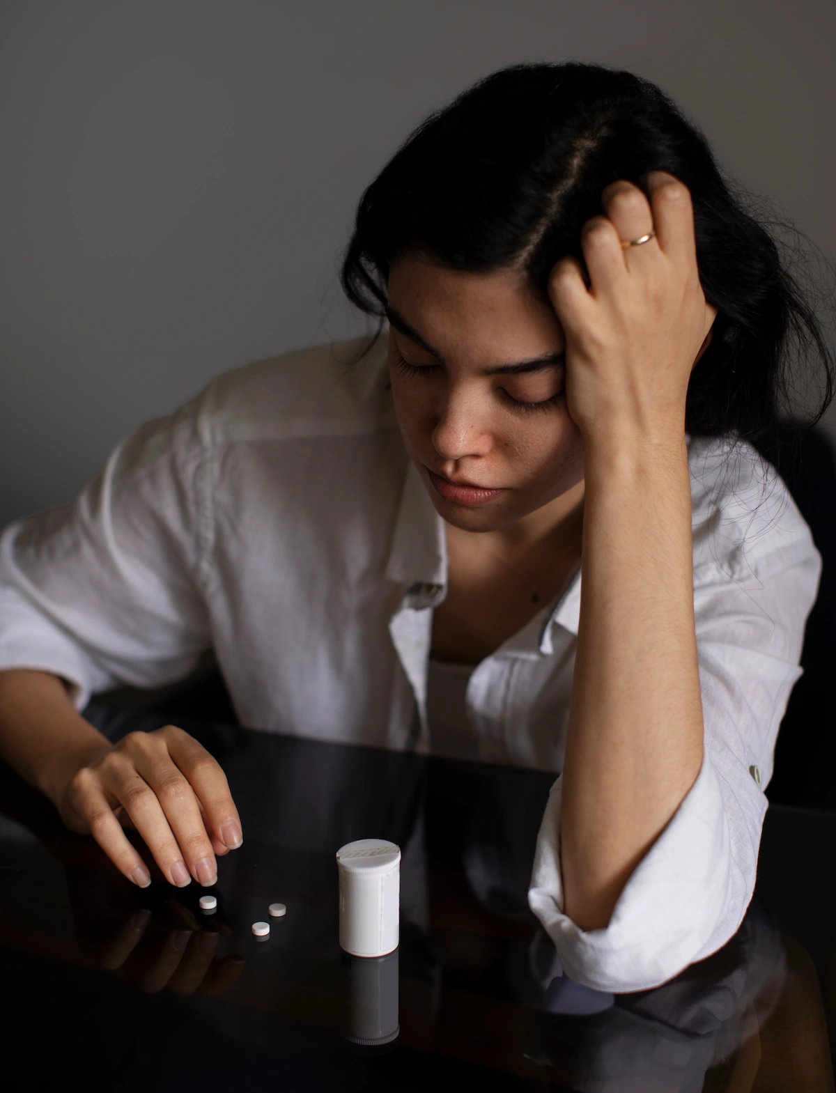 Women with heartburn looking at her meds
