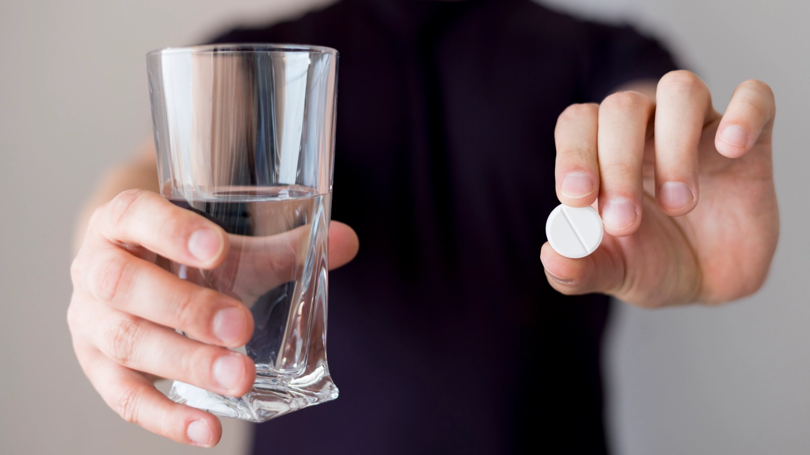 Man with Gerd holding glass of water and antacid