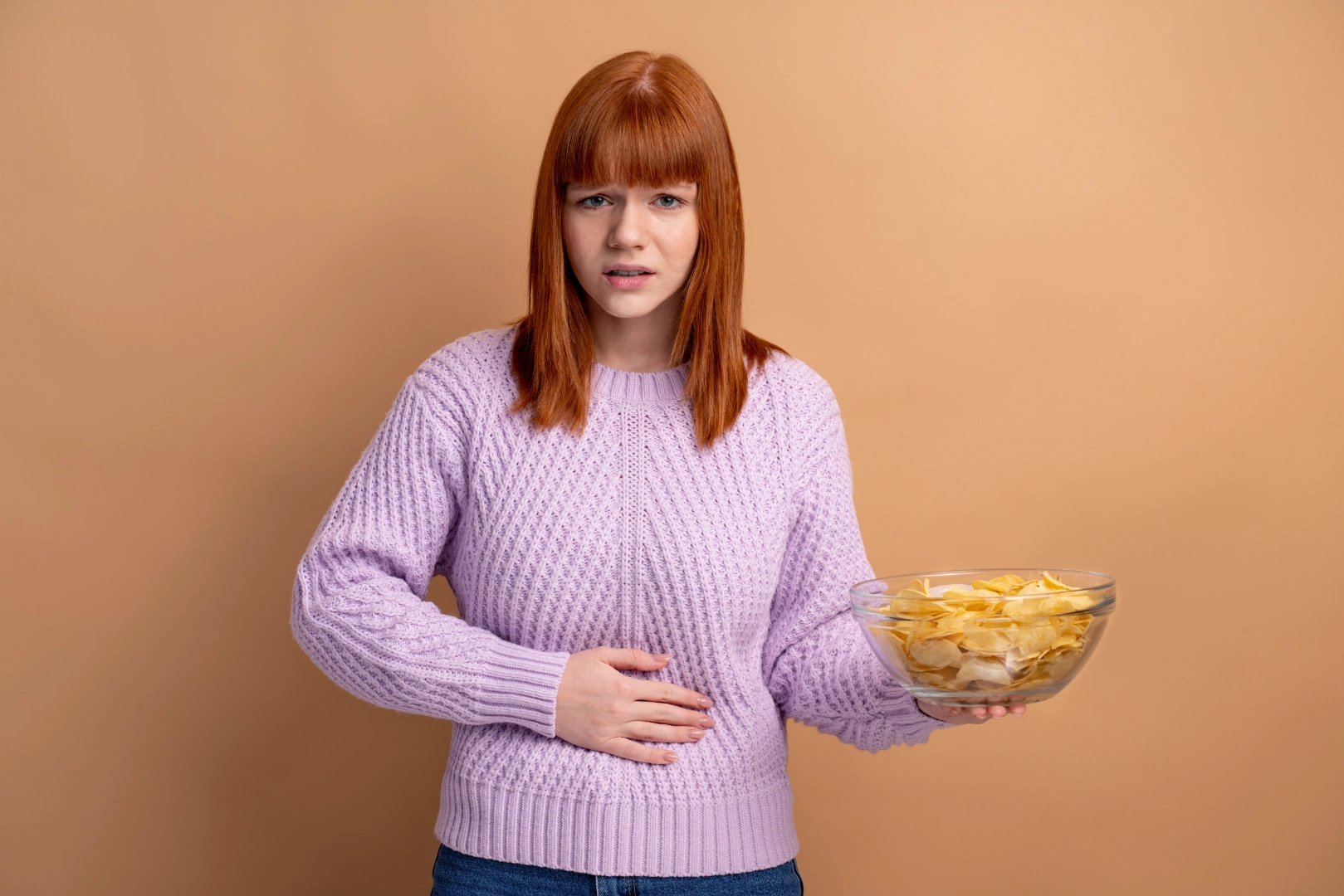 Woman with acid reflux holding unhealthy food