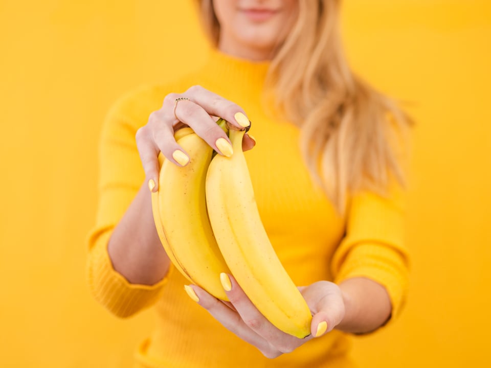 Women with heartburn holding banana