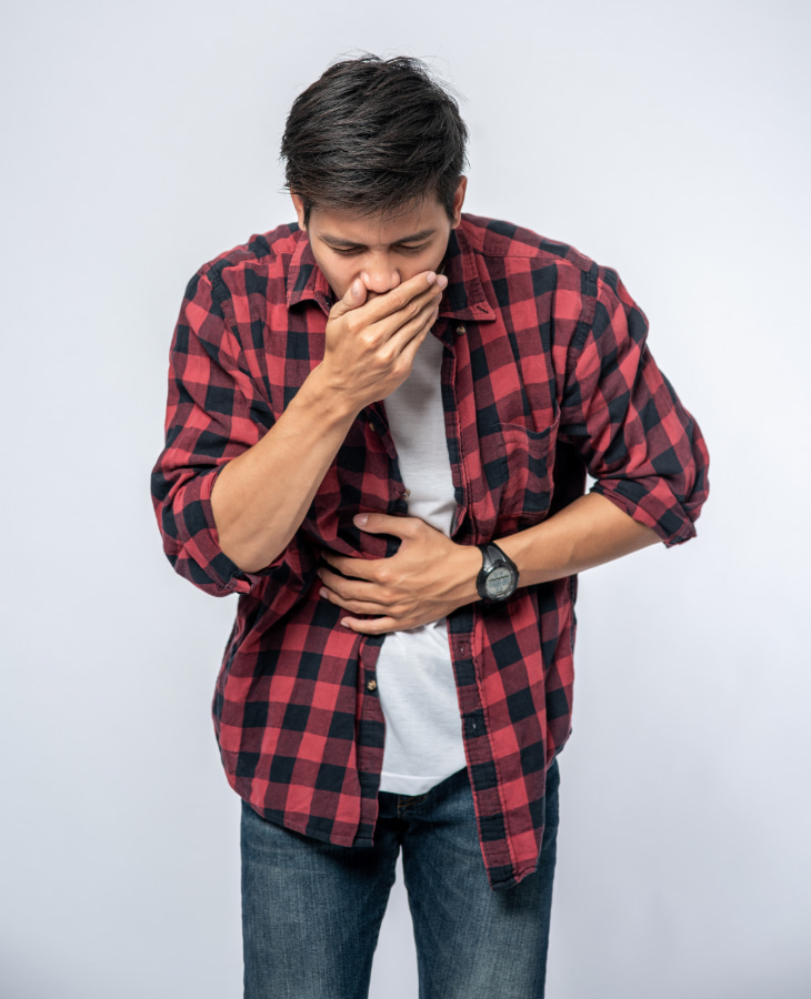 Man coughing while holding stomach Man coughing while holding stomach