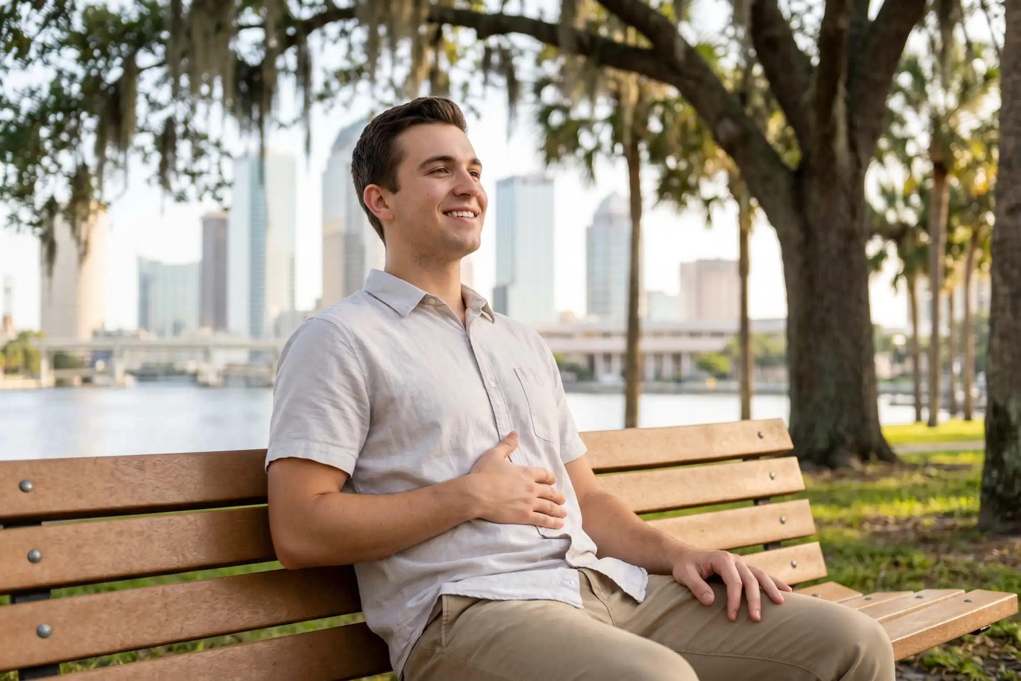 A relieved young man relaxing on a park bench in Tampa.