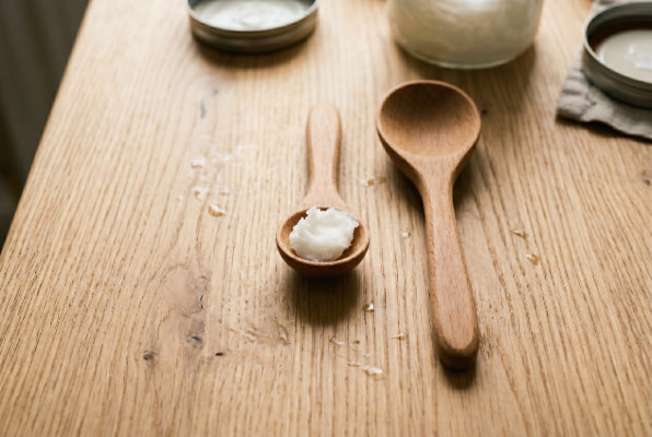 Small measured dose of coconut oil compared to a tablespoon for reflux