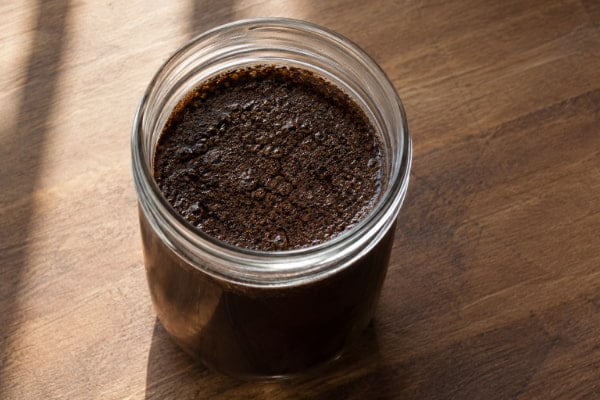 Cold brew decaf coffee steeping in glass jar, lower-acid brewing method for reflux