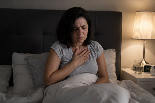 Woman with nighttime heartburn, a common acid reflux symptom