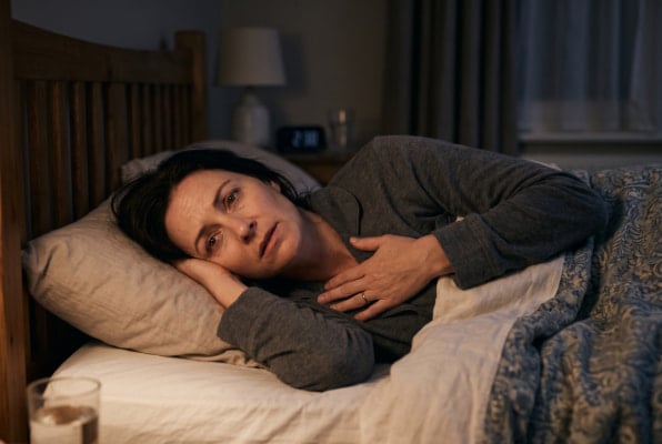 Woman awake at night with reflux, heartburn symptoms often get worse lying down