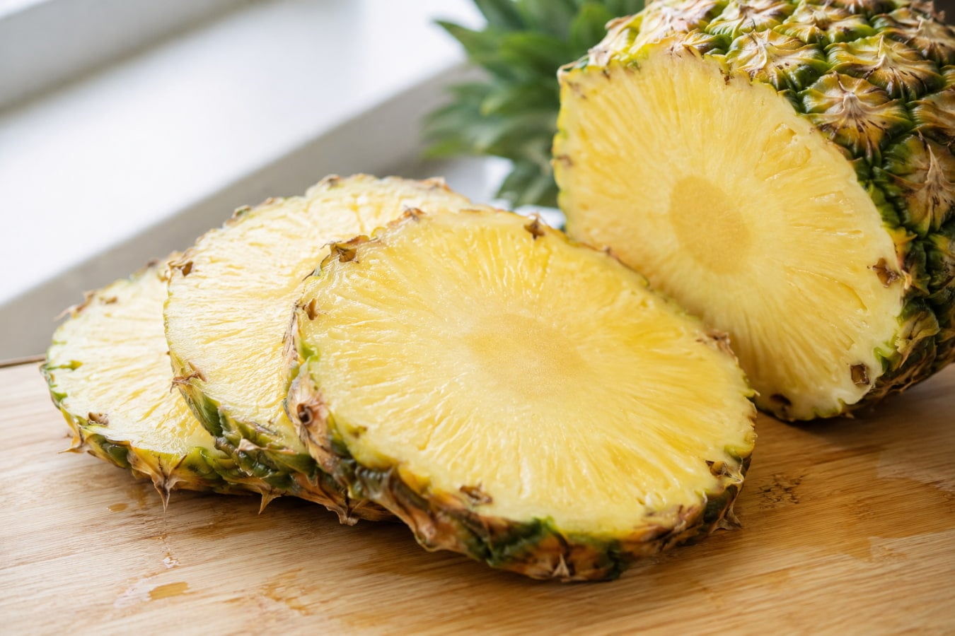 Fresh pineapple rings on a cutting board, a high-acid fruit measuring pH 3.20 to 4.00