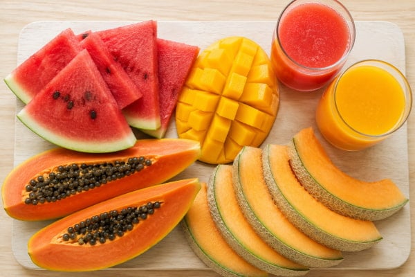 Watermelon, ripe mango, papaya and cantaloupe shown as low acid juice options for acid reflux