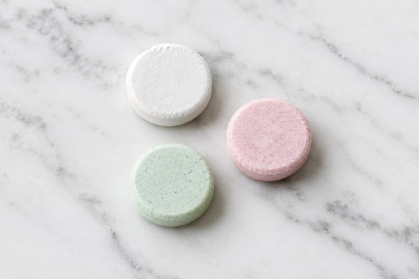 Close-up of calcium and magnesium antacid tablets on a clean white counter surface