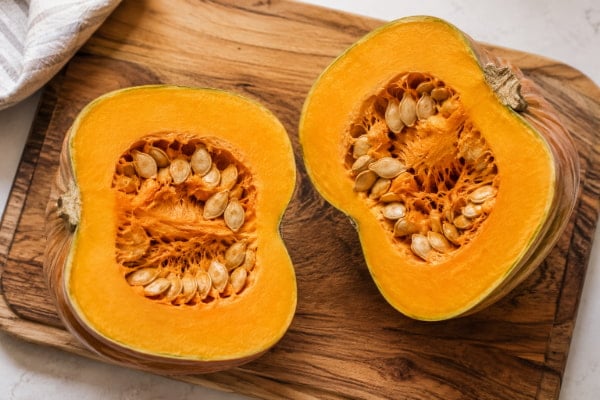Halved sugar pumpkin showing dense flesh and seeds, a low acid high fiber food
