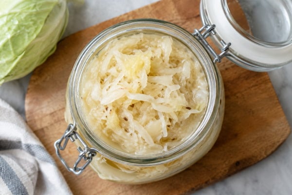 Raw fermented sauerkraut in a glass jar, a common food question for acid reflux