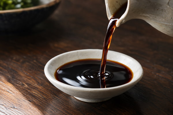 Soy sauce poured into a dipping dish, a high sodium acid reflux trigger for some